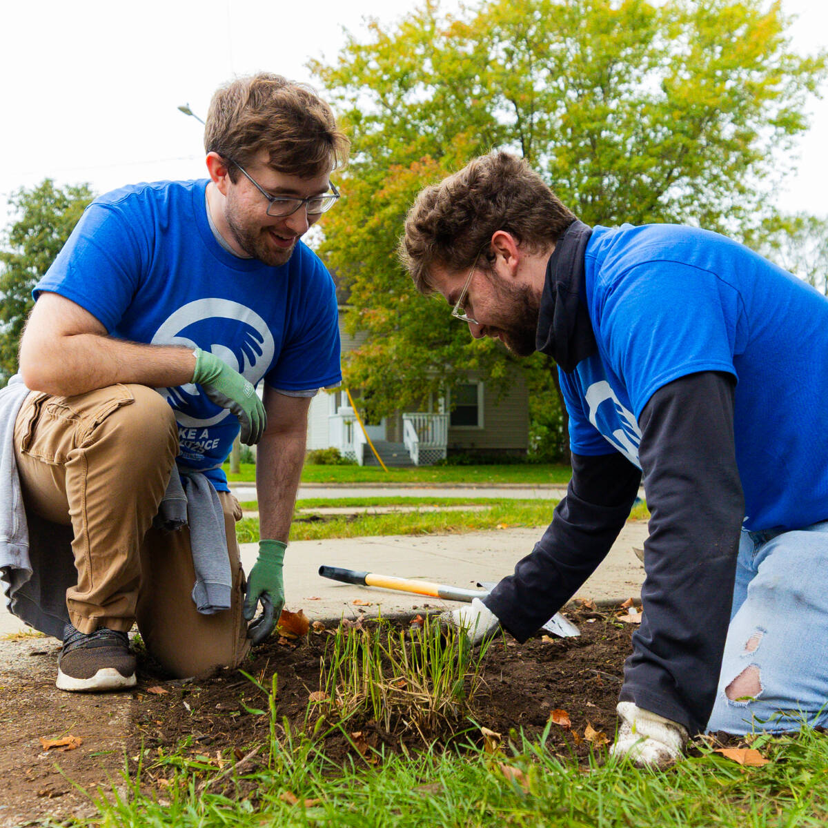 Two students planting plants in the ground
